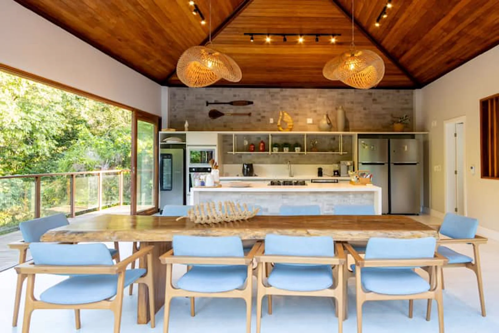 Cozinha e sala de jantar integradas, sob o teto de madeira