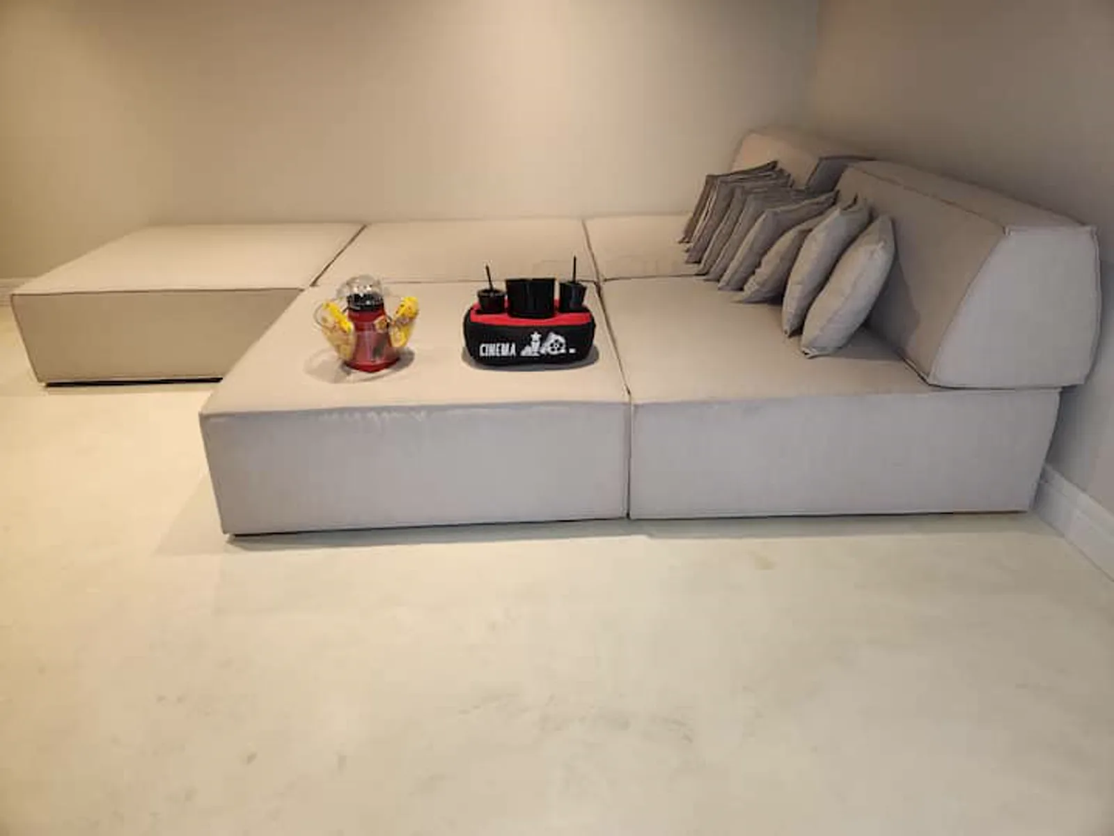 A sala de cinema da Vila Beija Flor, com sofá-cama modular e o kit de pipoca