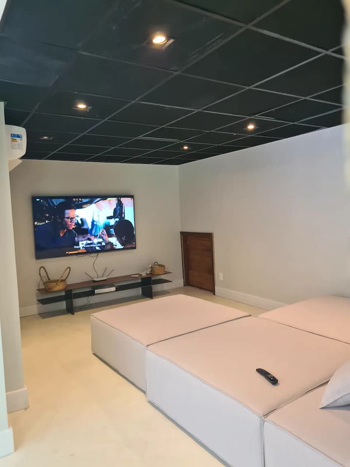 Sala de cinema com a TV e o sofá-cama modular